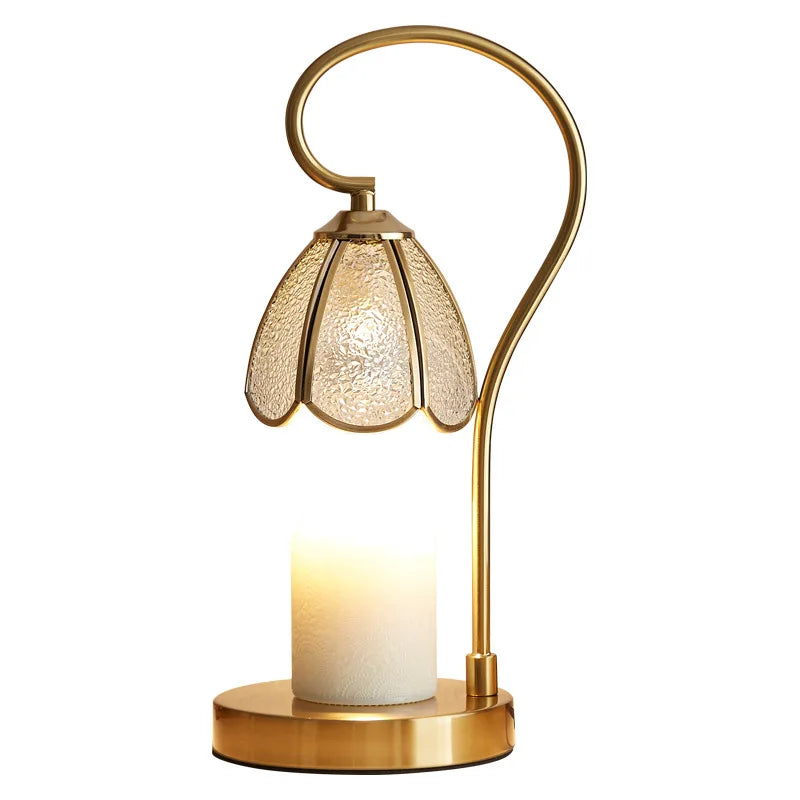 Gold table lamp with a textured glass shade on a white background