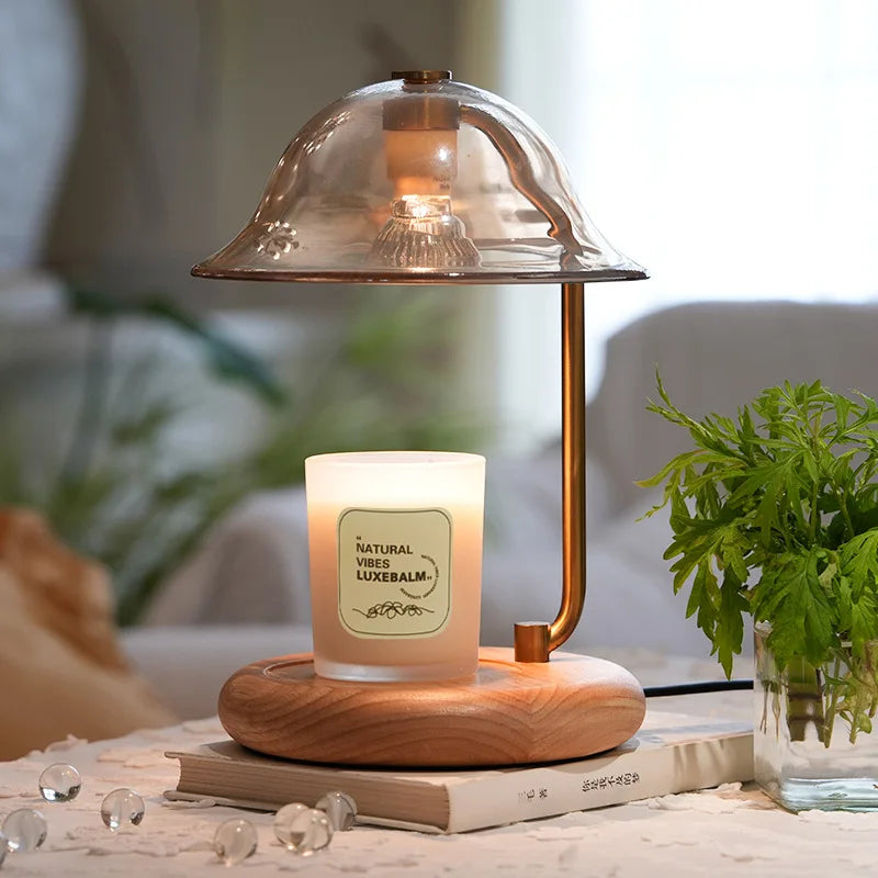 Candle with a glass cover on a wooden base, placed on books with a blurred background