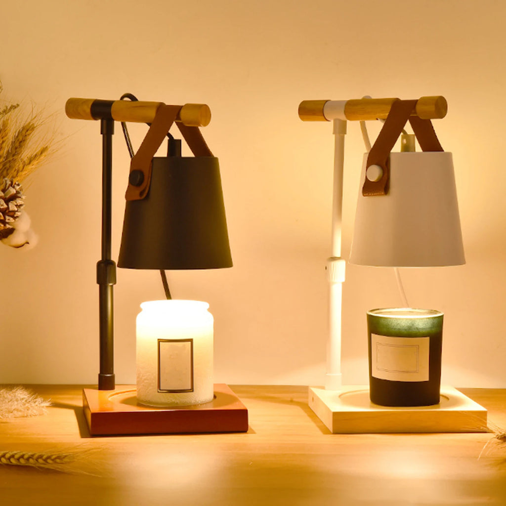 Two small lamps with candles inside on a wooden surface.