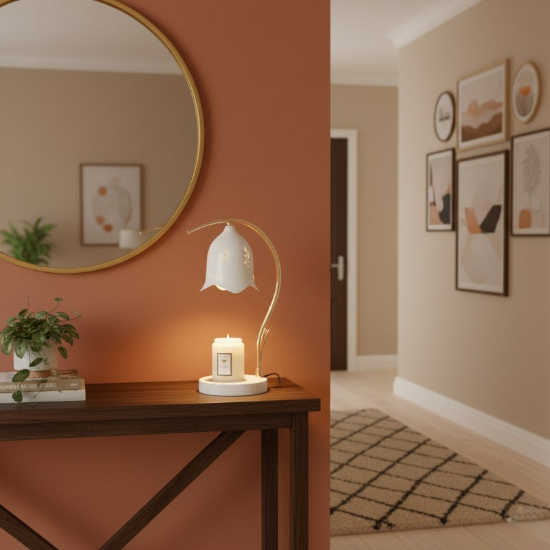 Decorative setup with a lamp, candle, and mirror on an orange wall.