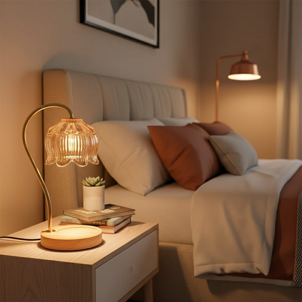 Cozy bedroom with a lit lamp on a nightstand, books, and decorative pillows.
